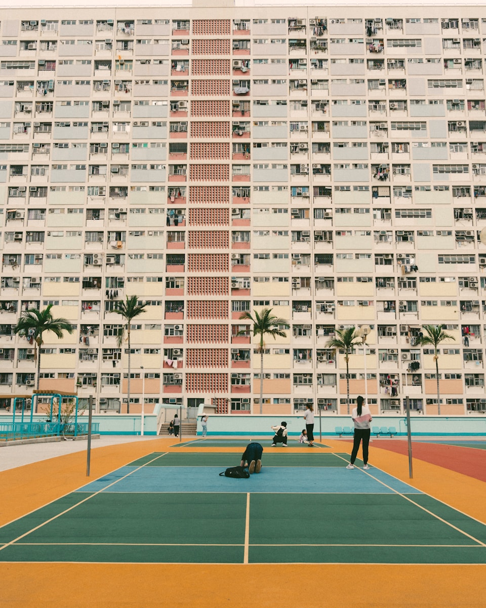 A vibrant badminton court in front of a large building.